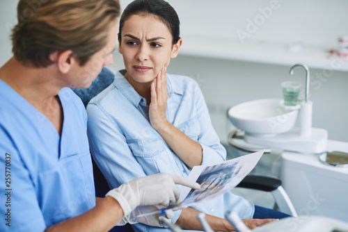 Young lady discussing her dental problems with dentist