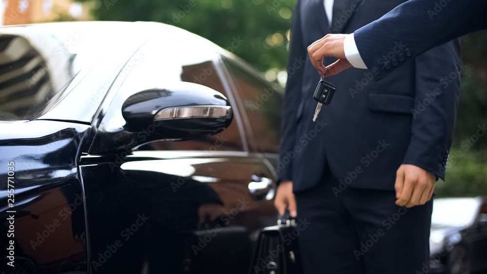 Hand giving car keys to businessman, renting luxurious auto for trip, purchase - obrazy, fototapety, plakaty 