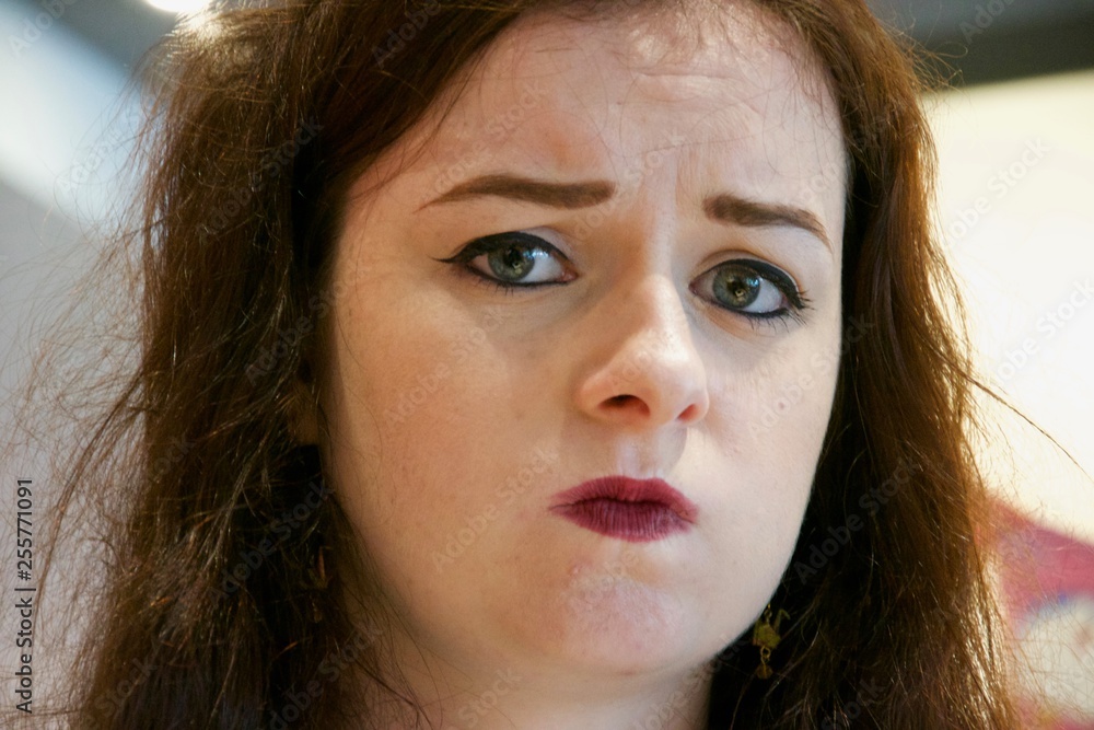 Close up round face pouting frowning lady Close up round face pouting frowning lady