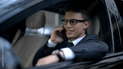 Successful businessman talking on phone with boss as sitting in car, good news © motortion