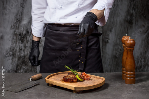 Chef in hotel or restaurant kitchen cooking only hands. Prepared beef steak with vegetable decoration