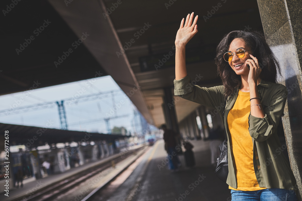 Beautiful girl with mobile phone meeting someone from train
