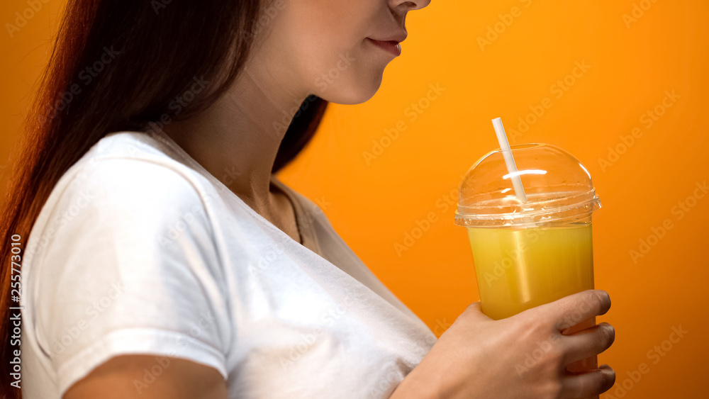 Young woman holding orange juice and smiling, healthy diet beverages, vitamins Young woman holding orange juice and smiling, healthy diet beverages, vitamins