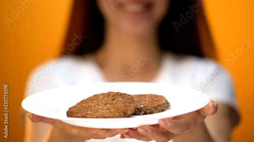 Woman holding cutlets, percentage of soya meat in burgers, fast food quality