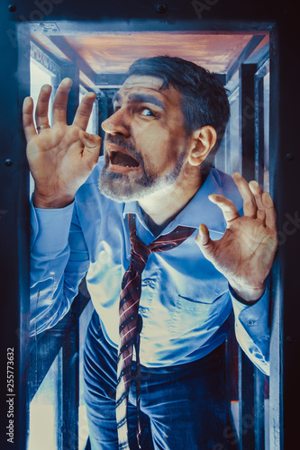 Businessman Inside of Glass Box. Concept of Captivity, No Freedom. Stressful Job, Pressure at Work. Lack of Space, Office Worker. Emotional Distress, Claustrophobia. photo