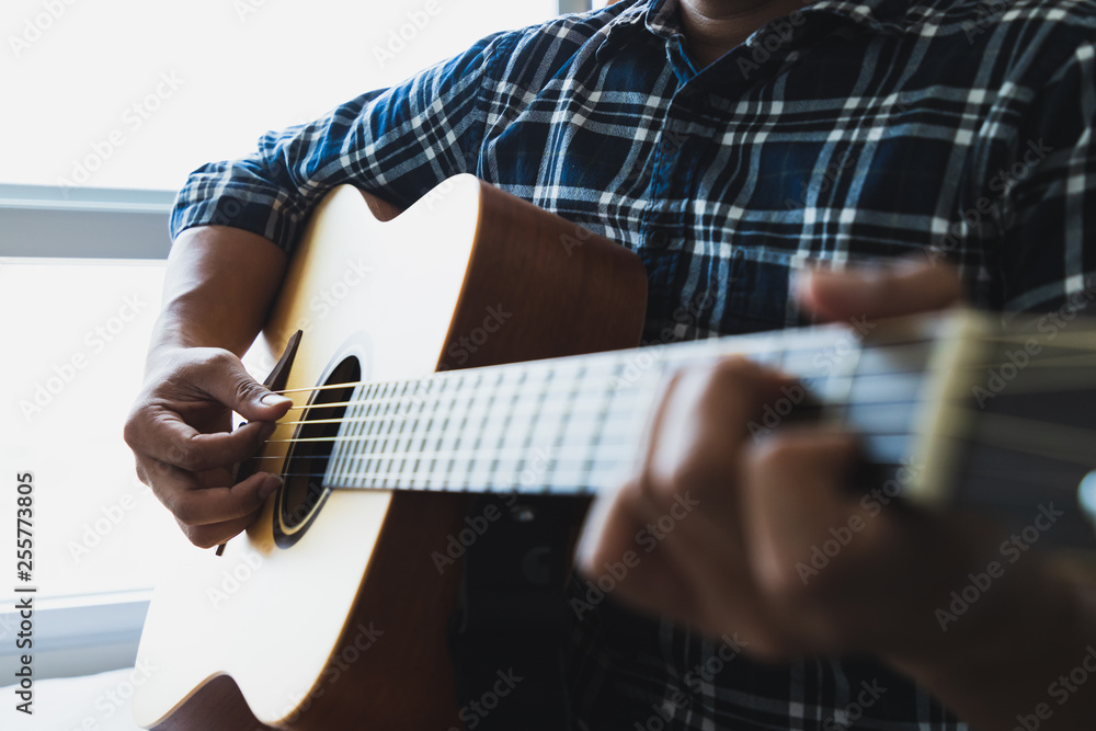 Close up men wearing blue plaid shirts playing guitar Close up men wearing blue plaid shirts playing guitar