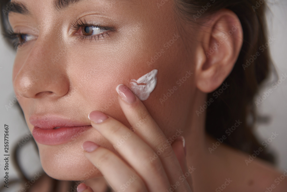 Close up of young sensual woman applying cream Close up of young sensual woman applying cream
