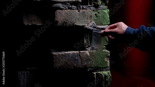 Photography Doper taking drug pills package from secret hideout and leaving place, smuggling
