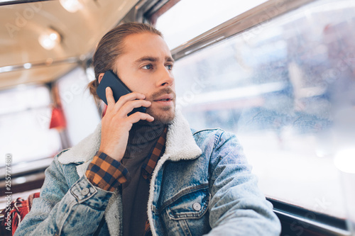 Hipster young male talk by phone in bus