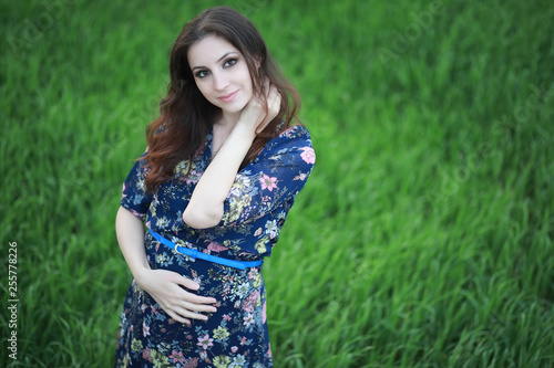 Pregnant girl in a dress in nature