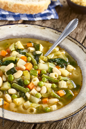 Fresh homemade vegetable soup made of zucchini, celery, carrot, peas, white beans, green beans, potato, tomato, spinach and ditali soup pasta(Selective Focus, Focus in the middle of the soup) photo