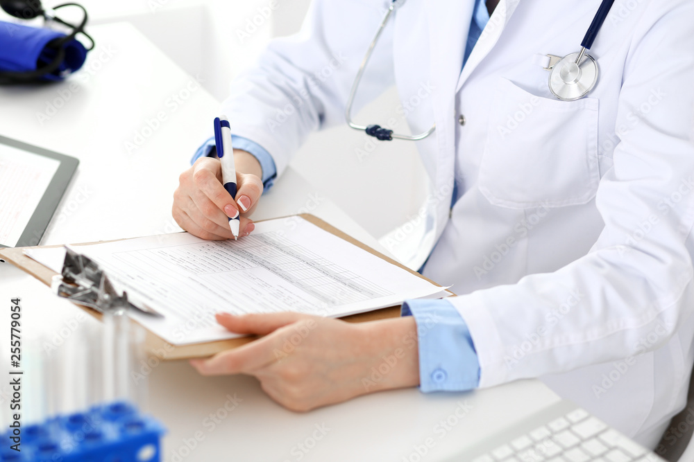 Female doctor using medical form on clipboard closeup. Physicianat work in hospital or clinic. Healthcare, insurance and medicine concept Female doctor using medical form on clipboard closeup. Physicianat work in hospital or clinic. Healthcare, insurance and medicine concept