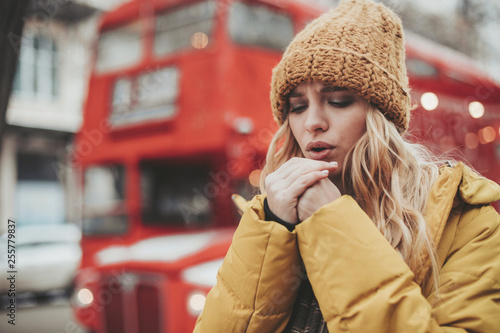 Young woman feeling very cold walking on street © Yakobchuk Olena