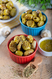 Wooden background with green olives, olive oil, garlic and spices