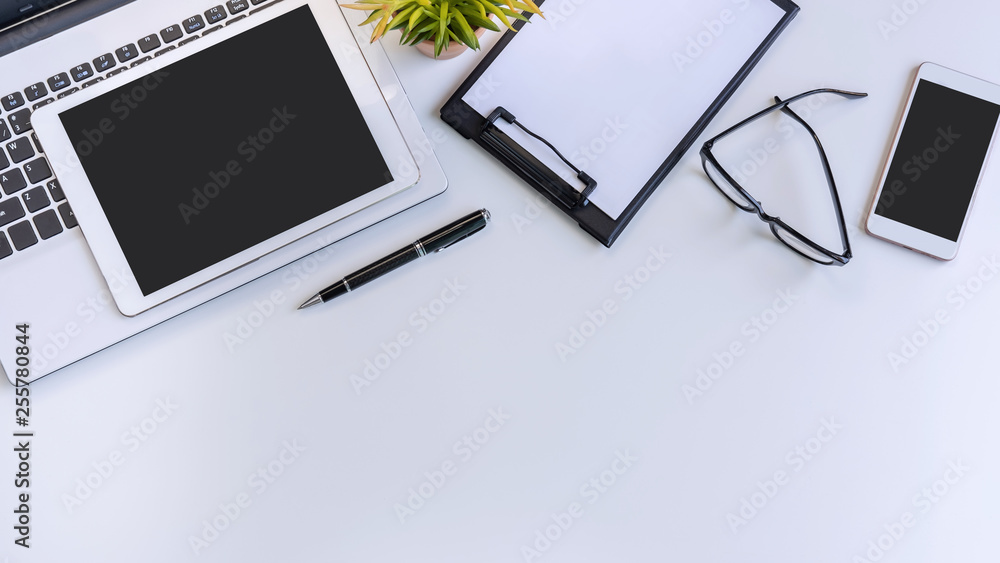 Empty screen Smart phone and tablet with laptop on business desk office with copy space, Top view