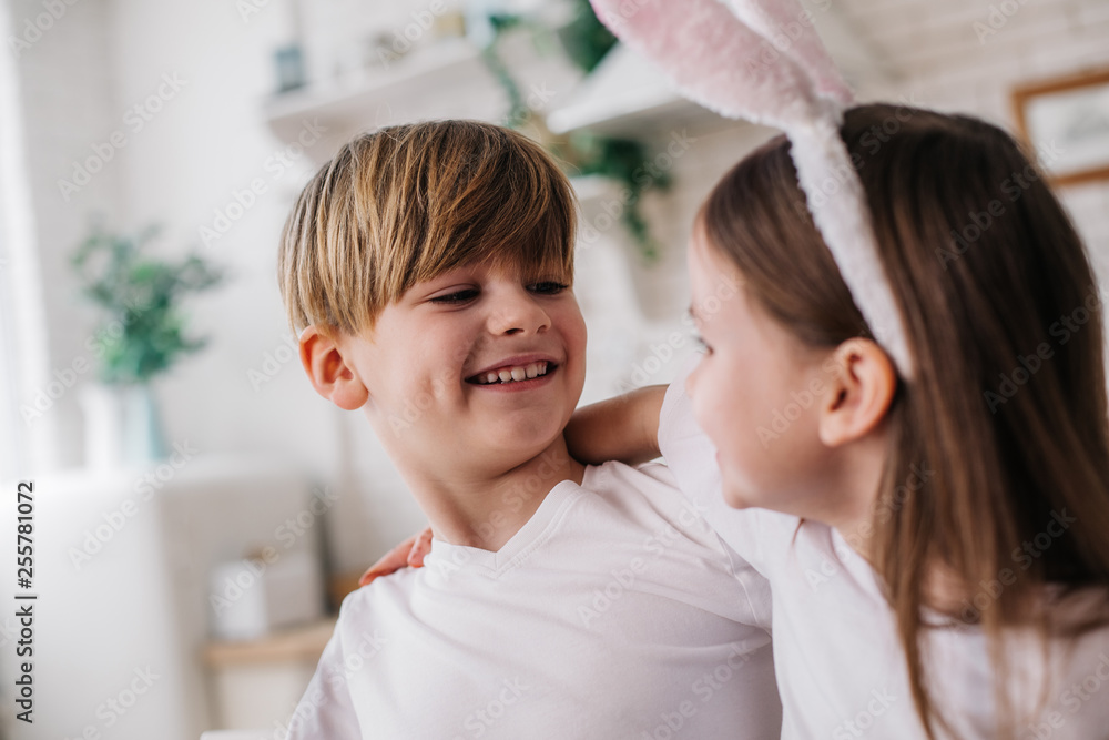 Low angle of happy boy hugging his sister at home Low angle of happy boy hugging his sister at home