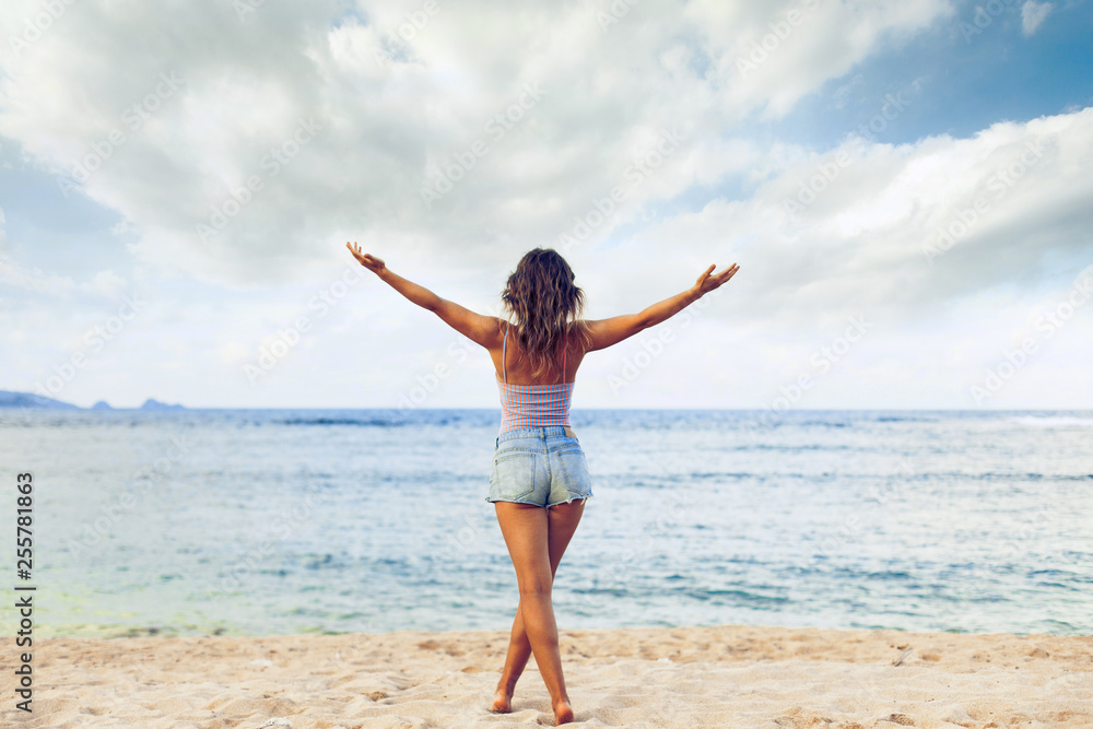 Freedom and happiness woman on beach. She is enjoying serene ocean nature during travel holidays vacation outdoors Freedom and happiness woman on beach. She is enjoying serene ocean nature during travel holidays vacation outdoors