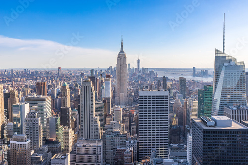 New York City Skyline in Manhattan downtown with Empire State Building and skyscrapers on sunny day with clear blue sky USA © Worawat