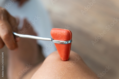 Close up Doctor doing examining knee reflex test