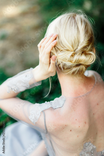 Stunning bride hair in beautiful wedding dress on natural background.