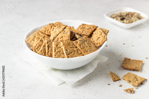 Obraz na płótnie Thin crispy salted multigrain crackers with seeds on grey concrete background