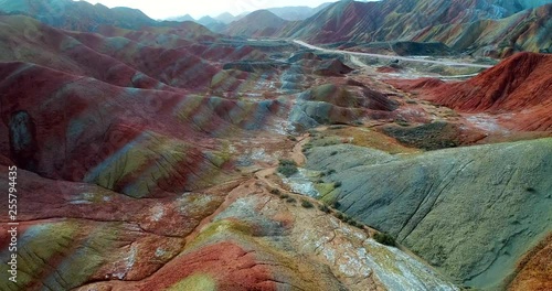Flying drone through breath-taking rainbow mountains. Aerial 4k footage showing the most beautiful valley in Zhangye National Geopark. Zhangye Danxia in Gansu Province, China. 