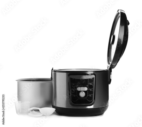 Disassembled electric multi cooker with accessories on white background
