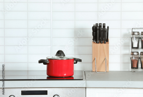 Clean pan and holder with knives in modern kitchen