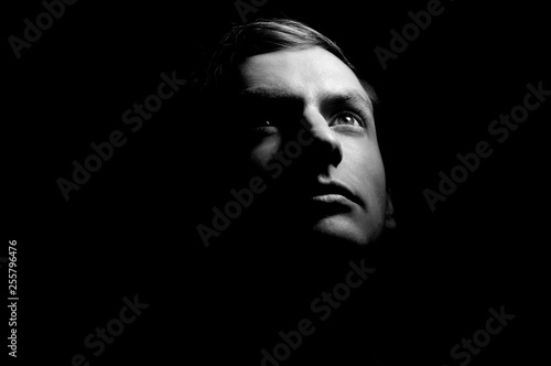 Dramatic portrait of a guy on a black background, black and white photography photo