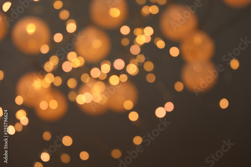 Blurred view of gold lights on dark background. Bokeh effect