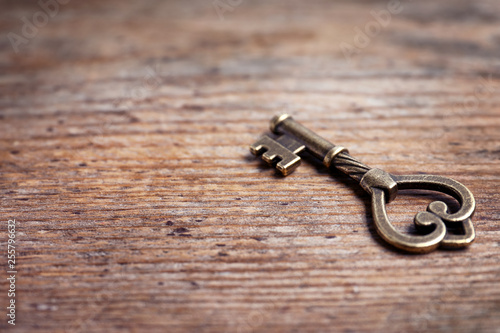 Old vintage key on wooden background, space for text © New Africa
