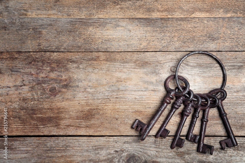 Obraz na plátně Bunch of old vintage keys on wooden background, top view with space for text
