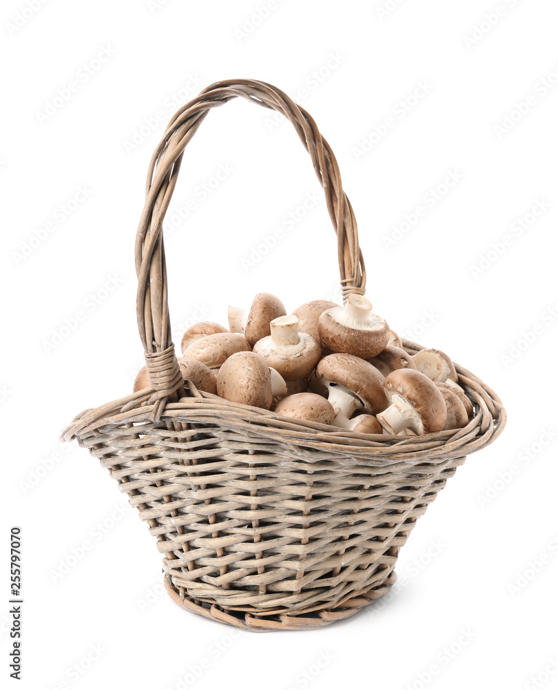 Wicker basket with fresh raw champignon mushrooms on white background Wicker basket with fresh raw champignon mushrooms on white background