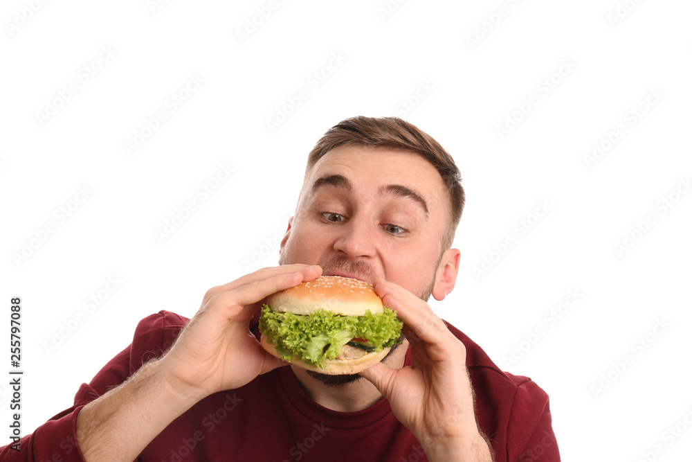 Young man eating tasty burger on white background Young man eating tasty burger on white background