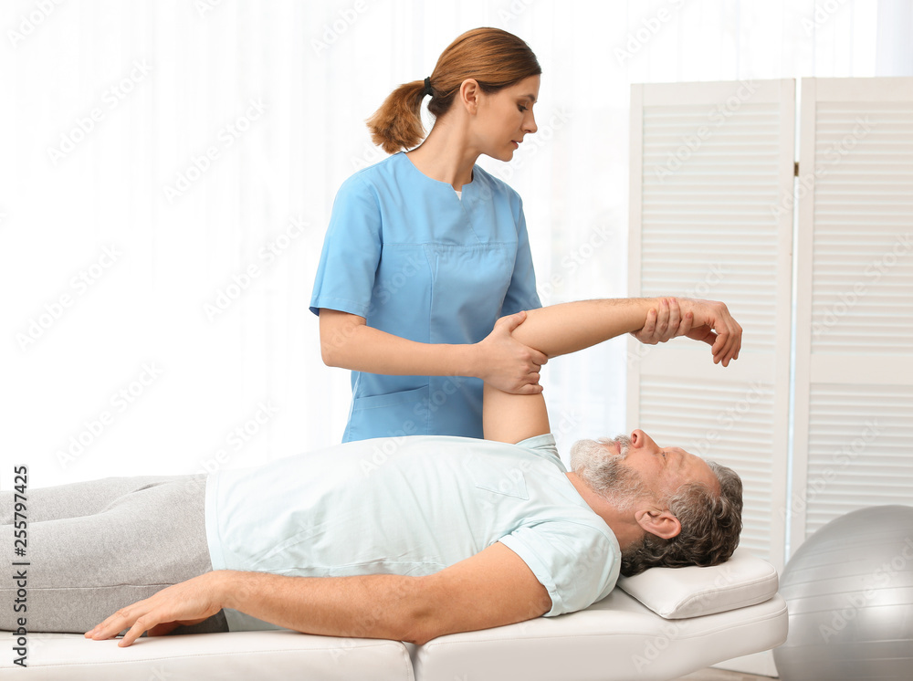 Physiotherapist working with patient in clinic. Rehabilitation therapy Physiotherapist working with patient in clinic. Rehabilitation therapy