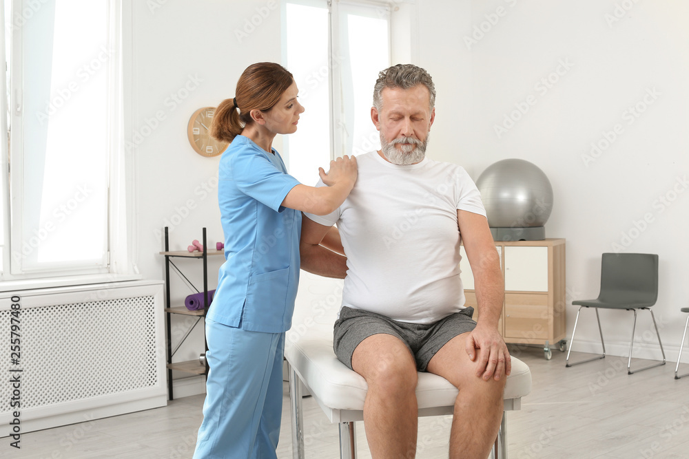 Physiotherapist working with patient in clinic. Rehabilitation therapy Physiotherapist working with patient in clinic. Rehabilitation therapy