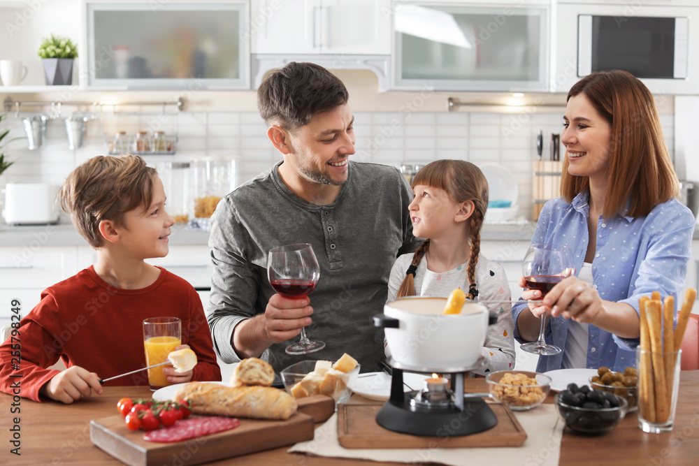 Happy family enjoying fondue dinner at home Happy family enjoying fondue dinner at home