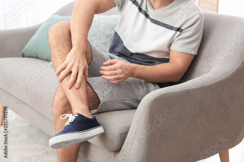 Man suffering from leg pain at home  closeup
