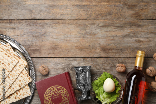 Flat lay composition with symbolic Passover (Pesach) items on wooden background, space for text photo