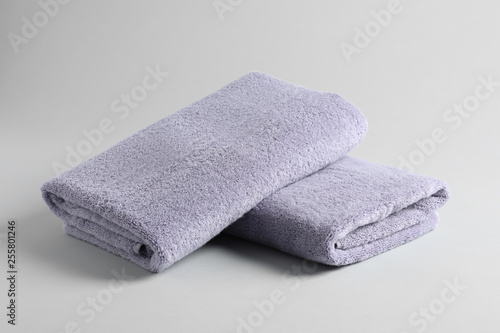Fresh fluffy folded towels on grey background