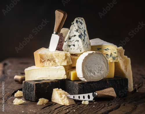 Assortment of different cheese types on wooden background. Cheese background. photo