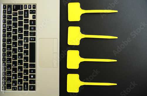 Fotografie Laptop Keyboard and Empty Yellow Labels isolated on Black Background