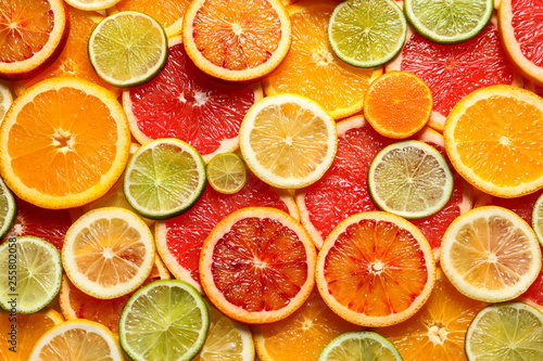 Slices of fresh citrus fruits as background  top view