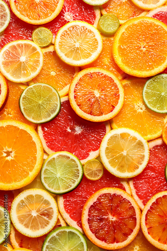 Slices of fresh citrus fruits as background  top view