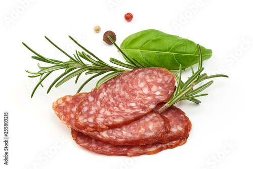 Dried salami slices with herbs, close-up, isolated on white background