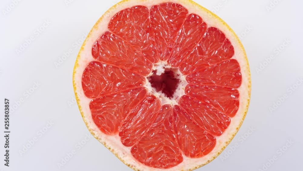 Fresh half of grapefruit citrus fruit on plate rotating. Healthy eating, weight loss, light meal. Top view Fresh half of grapefruit citrus fruit on plate rotating. Healthy eating, weight loss, light meal. Top view