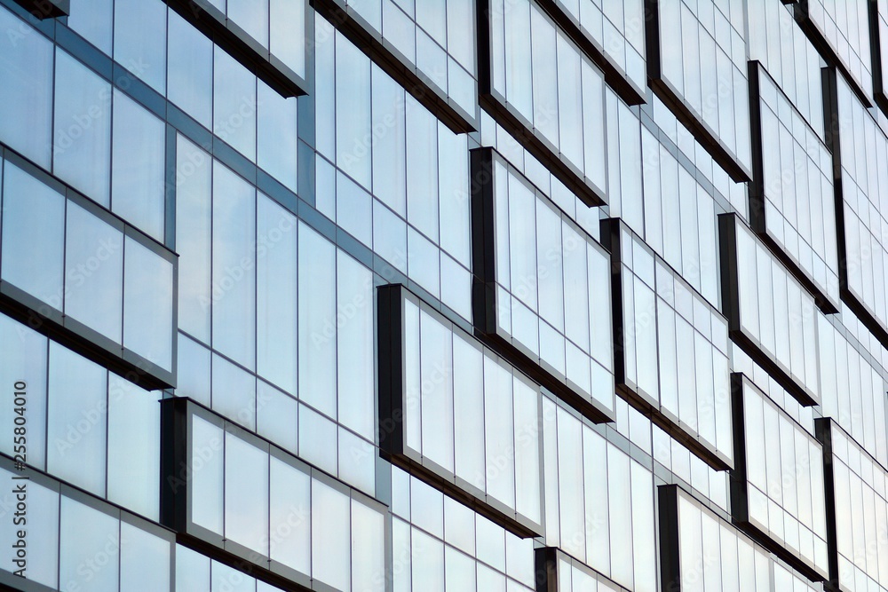 New office building in business center. Wall made of steel and glass with blue sky. New office building in business center. Wall made of steel and glass with blue sky.