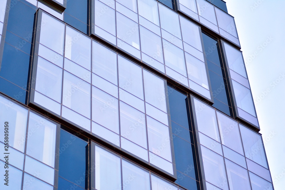 New office building in business center. Wall made of steel and glass with blue sky. New office building in business center. Wall made of steel and glass with blue sky.