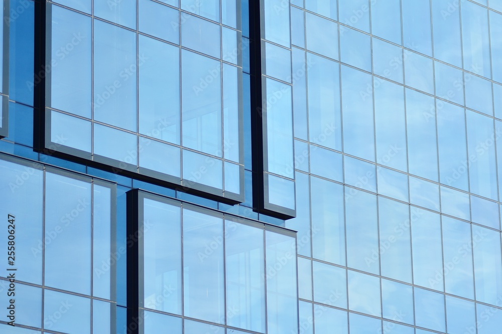 New office building in business center. Wall made of steel and glass with blue sky. New office building in business center. Wall made of steel and glass with blue sky.