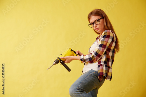Wallpaper Mural Emancipation woman skillfully holds a drill, standing between the boxes. Studio Torontodigital.ca